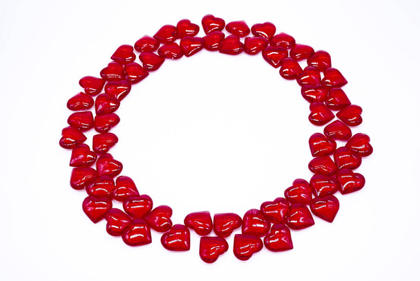 Bright red hearts are shiny, glass lie in the form of a round frame on a white background. Concept of love, marriage, wedding, Valentines day, passion. - Foto, immagini