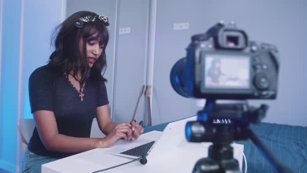 Afroamerikanische schwarze Frau arbeitet am Laptop und nimmt mit DSLR-Kamera auf - Filmmaterial, Video