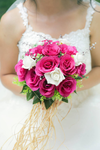 menyasszony kezében egy lila-fehér esküvői csokor virágot. Menyasszony, esküvői csokor - Fotó, kép