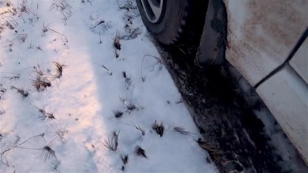 Zavřít kolo silného auta na sněhu začíná pohyb s klouzačkou a sprejem letí přímo do kamery - Záběry, video
