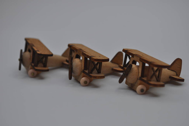 Close-up creatieve opnamen van kleine houten vliegtuigmodellen handgemaakt van hout, ongeveer 3 cm x 2 cm groot - Foto, afbeelding