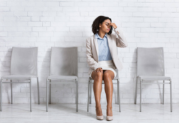 Afroamerykanka w stroju biznesowym zmęczona czekaniem na rozmowę kwalifikacyjną, bólem głowy w biurze, przestrzenią do kopiowania - Zdjęcie, obraz