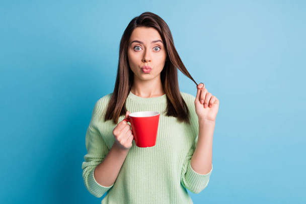Photo of lovely girl make lips plump hold cappuccino cup touch hairstyle isolated over blue color background - Fotografie, Obrázek