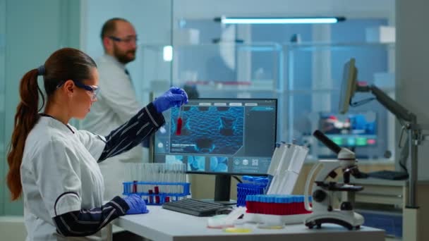 Χημικός γιατρός που αναλύει το δείγμα αίματος και δακτυλογραφεί στον υπολογιστή - Πλάνα, βίντεο