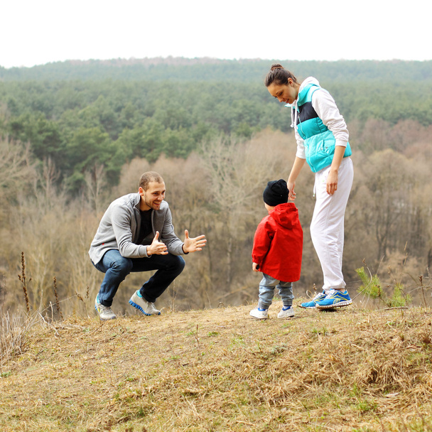 Bela jovem família desportiva fica de volta na montanha
 - Foto, Imagem
