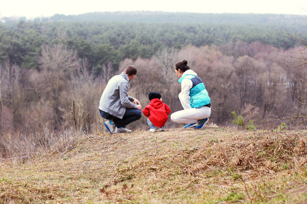 Bela jovem família desportiva fica de volta na montanha
 - Foto, Imagem