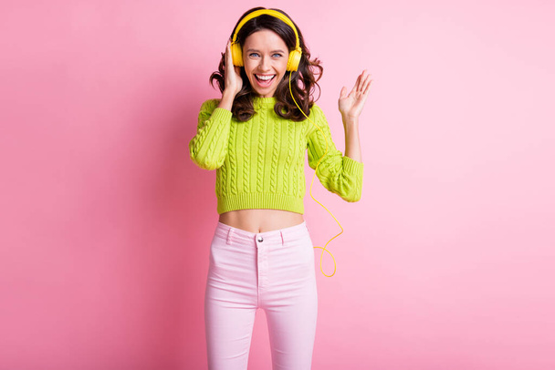Photo of lovely curly woman dressed green pullover dancing listening music headphones isolated pink color background - Foto, Imagen