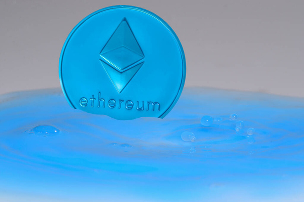 blue ether coin in a blue fluid with drops and grey background - Photo, Image