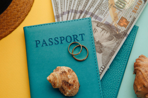 Huwelijksreis reisconcept. Paspoorten met geld en schelpen close-up op een blauw-gele achtergrond - Foto, afbeelding