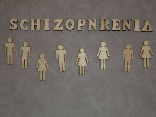 duševní choroba-schizofrenie ve formě dřevěných písmen a figurek lidí na šedém pozadí - Fotografie, Obrázek