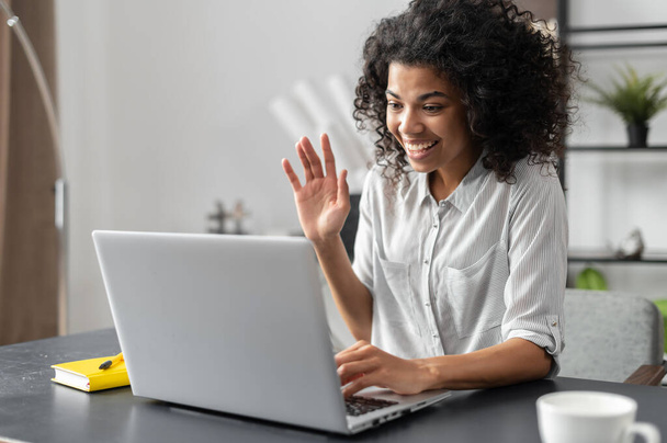African American woman waving at the laptop screen - 写真・画像
