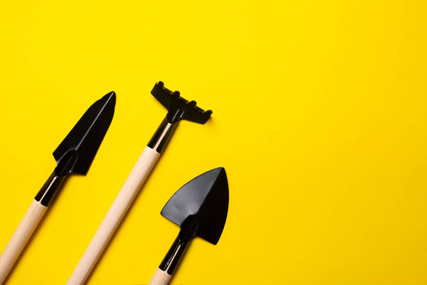 Garden shovels on a yellow background . Gardening layout. Spring planting. The care of plants. Work in the ground. yellow background. Copy space. - Fotoğraf, Görsel