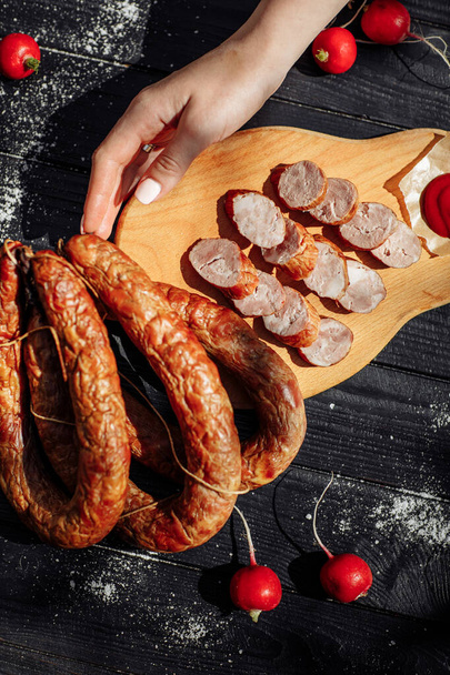 Traditional sausages smoked in apple, beech and juniper wood. closeup on a wooden board. High quality photo - Photo, Image