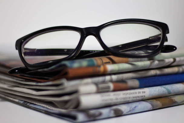 Stack of newspapers and glasses in black and white. - Valokuva, kuva