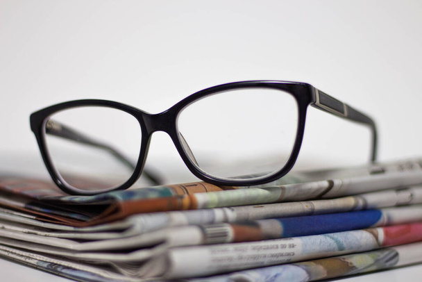Stack of newspapers and glasses in black and white. - Fotó, kép