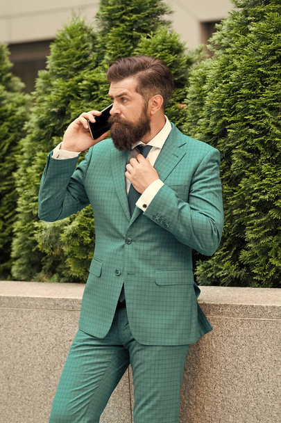 Business call. Stylish guy wear tuxedo. Stay connected. Businessman talk mobile phone. Handsome bearded man with cell phone outdoor. Mobile lifestyle. Business communication. Mobile technology - Fotografie, Obrázek