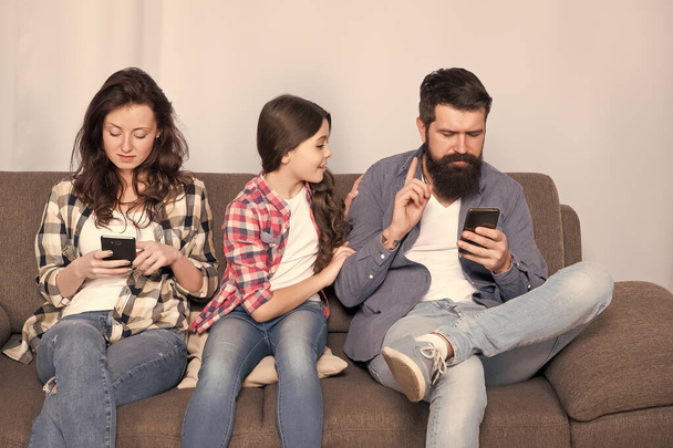 Online family meeting. Little child and parents use cellphones at home. Mobile communication. Cellular communication. Communication technology. Mobile internet and family communication. Modern life - Foto, imagen