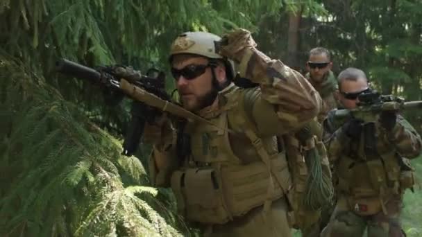 Primo piano medio di squadra di forze speciali con fucili su operazione segreta in giungla, indagando il territorio - Filmati, video