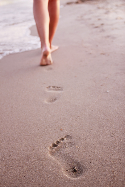 női lábnyomok a homokba  - Fotó, kép