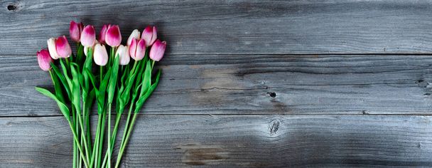 Overhead view of pink tulips on rustic wood for Mothers Day or Easter concept  - Photo, Image