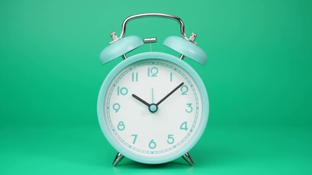 Time lapse, el despertador azul muestra el correr del tiempo. El movimiento de las manecillas del reloj pasó rápidamente. Sobre el fondo verde. - Imágenes, Vídeo