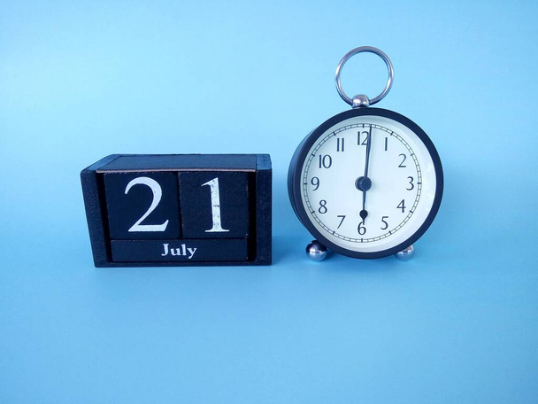 Alarm klok geïsoleerd op blauwe achtergrond met datum - Foto, afbeelding