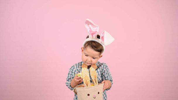 Kind und Ostern, auf rosa Hintergrund. Hochwertiges Foto - Foto, Bild