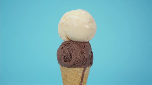Zmrzlina Čokoládový kornout na vrcholu Vanilka, Closeup pohled zepředu Jídlo koncept. Na modrém pozadí - Záběry, video