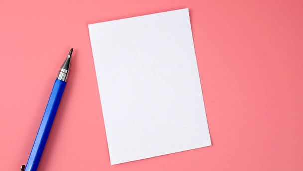 Niebieski ołówek i biały pusty papier izolowany na różowym tle, Widok z góry Blank dla projektu. - Zdjęcie, obraz