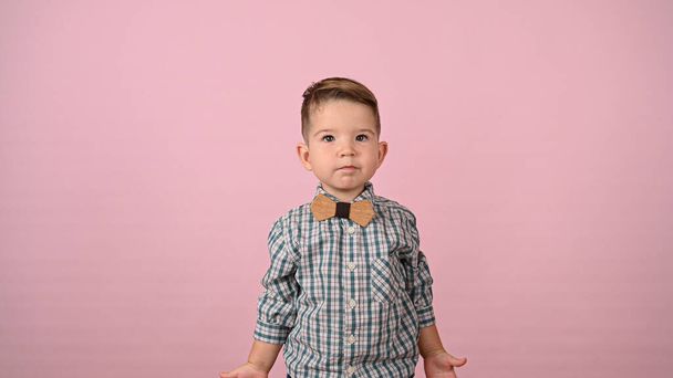 dziecko w koszuli i muszce, na różowym tle. Wysokiej jakości zdjęcie - Zdjęcie, obraz