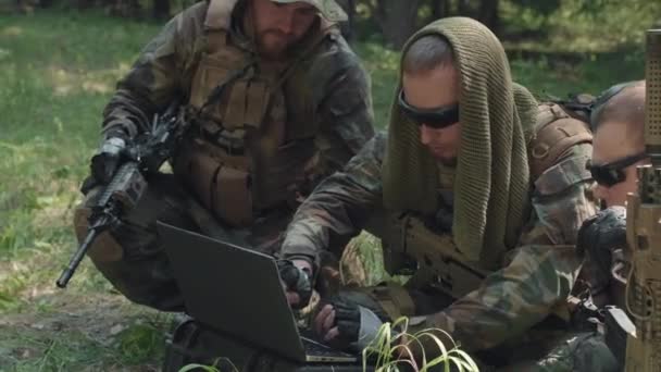 Tiro médio de oficiais de exército no disfarce de camuflagem usando computador portátil, executando a operação militar perigosa na selva - Filmagem, Vídeo