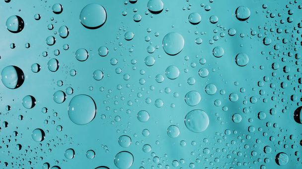 Gotas de agua en el fondo de la superficie de la ventana de vidrio de color turquesa. transparente transparente gotas de agua macro abalorios fondo de pantalla - Foto, Imagen