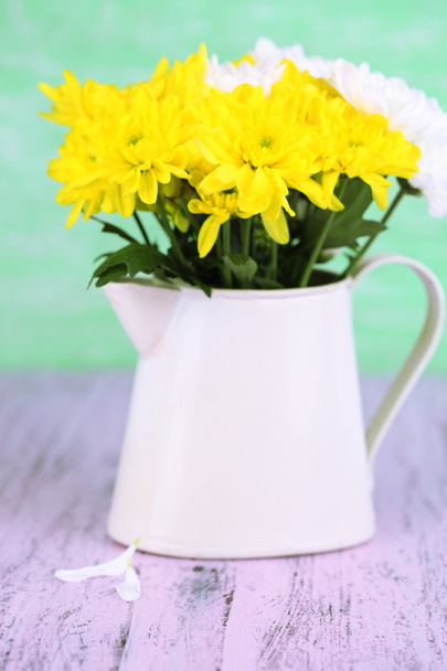 Beautiful chrysanthemum flowers in pitcher on wooden table - Foto, immagini