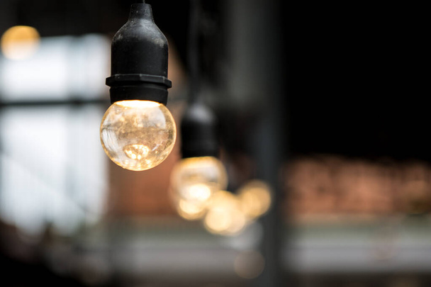Selektiver Fokus von Glühbirnen in Cafés auf verschwommenem Hintergrund - Foto, Bild