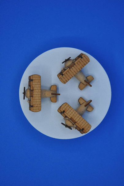 Κοντινές δημιουργικές λήψεις μικρών μοντέλων ξύλινων αεροπλάνων χειροποίητων από ξύλο, διαστάσεων περίπου 3cm X 2cm - Φωτογραφία, εικόνα