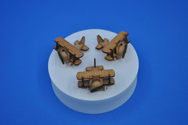 Tahtadan yapılmış küçük ahşap uçak modellerinin yaratıcı çekimlerini kapat. Boyutları yaklaşık 3 cm X 2 cm. - Fotoğraf, Görsel