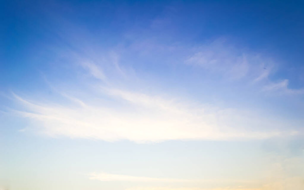 Θολή φόντο του ουρανού μαλακά σύννεφα κίνηση του ανέμου σε γαλάζιο κίτρινο χρυσό χρώμα - Φωτογραφία, εικόνα
