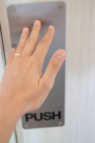 Woman hand pushing the door, stock photo - Φωτογραφία, εικόνα