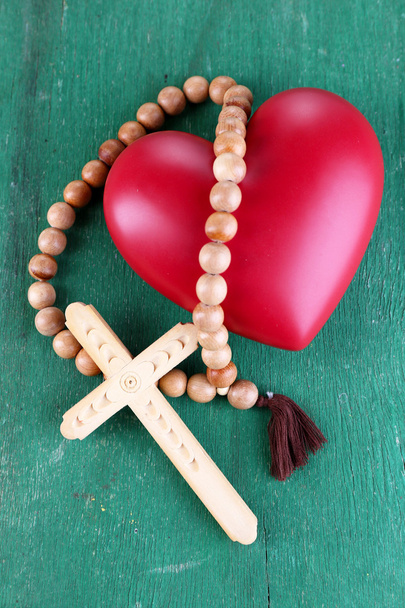Heart with rosary beads on wooden background - Foto, Imagen