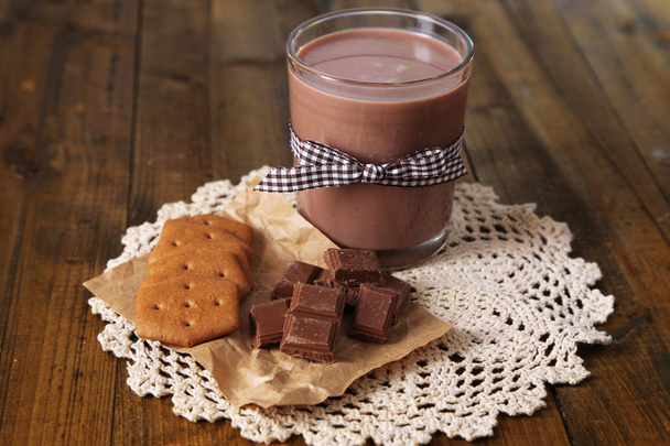 Chocolate milk in glass, on wooden table background - Foto, immagini