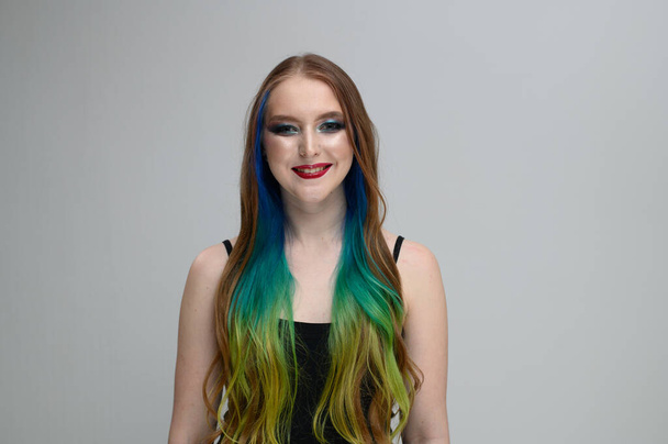 Portrait of a girl with excellent makeup with a smile with dyed hair - Photo, image