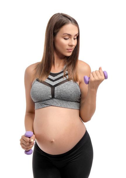 Όμορφη έγκυος γυναίκα με αλτήρες κατάρτισης σε λευκό φόντο - Φωτογραφία, εικόνα