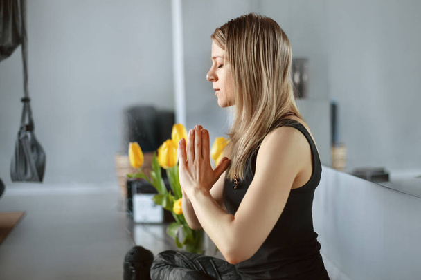 Une belle jeune fille médite après un cours de yoga. Repos, relaxation, mode de vie sain - Photo, image