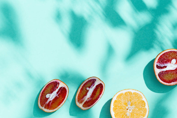 Rebanadas brillantes cítricos, pomelo, naranja sobre fondo de color turquesa pastel. Comida de frutas y concepto de verano. - Foto, Imagen