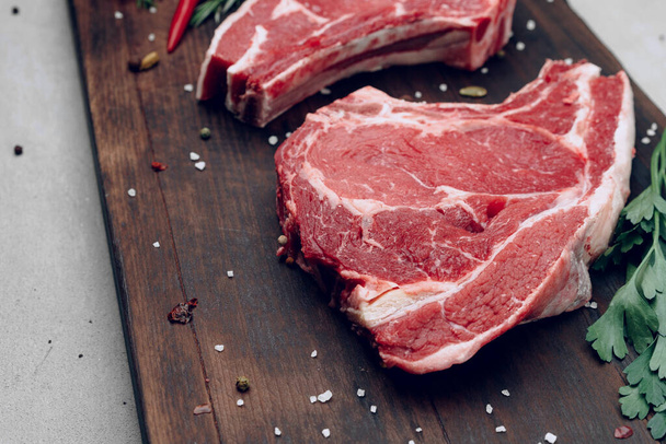 Raw beef meat fillet on wooden board - Foto, afbeelding