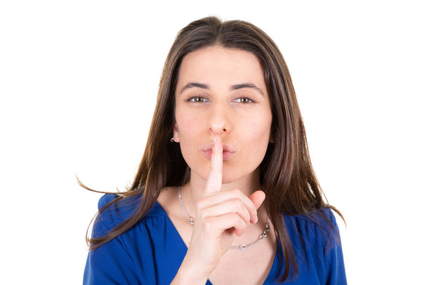Девушка, прислонившись пальцем к губам, молчаливым жестом - Фото, изображение