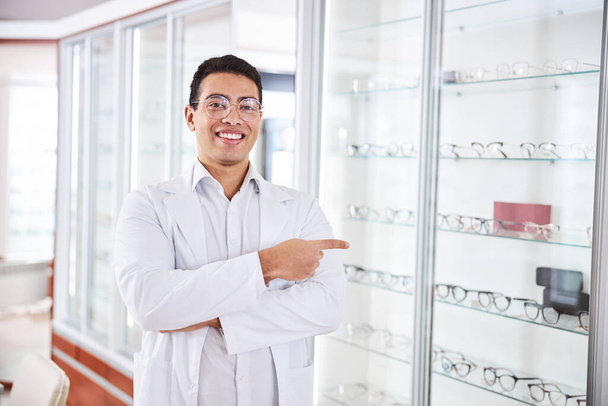 Улыбающийся оптический консультант в очках, глядя вперед - Фото, изображение