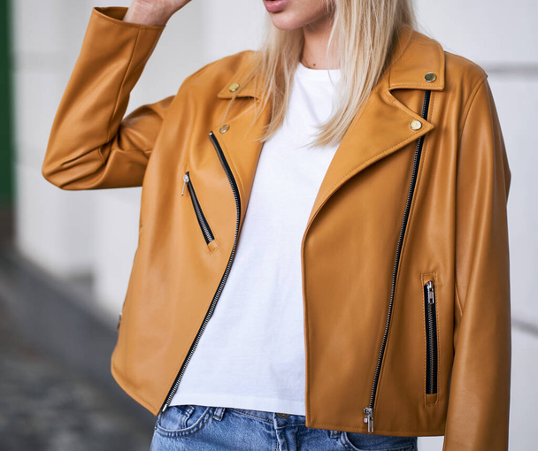 Woman wears yellow jacket during fall season. Beautiful blonde girl standing in the casual style street wear. Successful woman template - Photo, Image