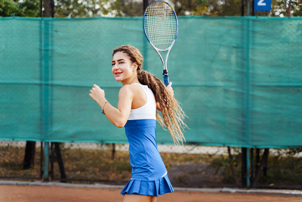 Красивая, молодая спортсменка любит проводить время на теннисном корте. Мощный удар вперед. Подготовка к получению мяча от противника. Как можно более целенаправленно и собранно. - Фото, изображение