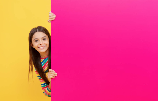 щаслива дівчинка за рожевим паперовим листом з копіювальним простором, розпродаж
. - Фото, зображення